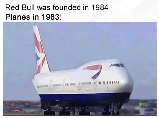 A meme contrasting Red Bull's founding year (1984) with the existence of planes in 1983, humorously referencing Red Bull's iconic slogan 'Red Bull gives you wings.' The top text establishes the timeline: 'Red Bull was founded in 1984 Planes in 1983:' followed by a photograph of a commercial airplane (likely a British Airways Boeing 747) with a noticeably tilted posture, visually implying that planes already had literal 'wings' before Red Bull's marketing claim. The tilted plane adds comedic effect, suggesting instability or a playful nod to the absurdity of the comparison.