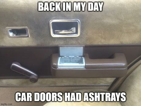 The image is a photograph of a vintage car door interior, focusing on a built-in ashtray. The top of the image contains the text 'BACK IN MY DAY' in bold, uppercase letters, and the bottom text reads 'CAR DOORS HAD ASHTRAYS', also in bold, uppercase. The photo appears to be of an older car model, emphasizing the now-outdated feature of car doors having ashtrays. The tone is nostalgic, humorously commenting on how such features have become obsolete in modern cars.