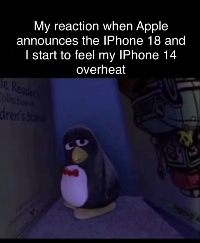 This meme has top text that reads 'My reaction when Apple announces the iPhone 18 and I start to feel my iPhone 14 overheat' placed above an image of Wheezy, the squeaky penguin character from the Toy Story franchise, sitting dejectedly in a dim, blue-lit corner looking tired and resigned. The joke plays on the widely discussed consumer trope and accusation of planned obsolescence for Apple products, implying that older iPhone models immediately develop performance issues like overheating as soon as a far newer generation of the device is announced.