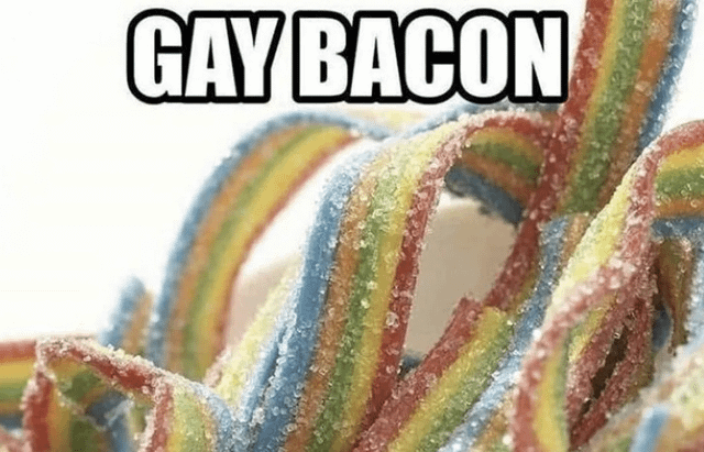 This is a single-panel pun meme featuring a close-up shot of wavy, rainbow-striped sour gummy candy strips coated in coarse sugar crystals. The long, curved shape of the gummy strips visually resembles strips of bacon, while their rainbow color palette is the widely recognized symbol of the LGBTQ+ pride movement. Bold white text with a thick black outline is placed at the top of the image, reading 'GAY BACON', creating a silly joke that combines the candy's appearance and pride symbolism for humorous effect.