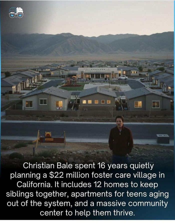 The image shows a residential village with multiple homes, a playground, and a community center set against a mountainous backdrop in California. In the foreground stands Christian Bale, looking toward the village. Overlaid text explains that Bale spent 16 years planning this $22 million foster care village, which includes 12 homes designed to keep siblings together, apartments for teens aging out of the foster care system, and a community center to support residents.