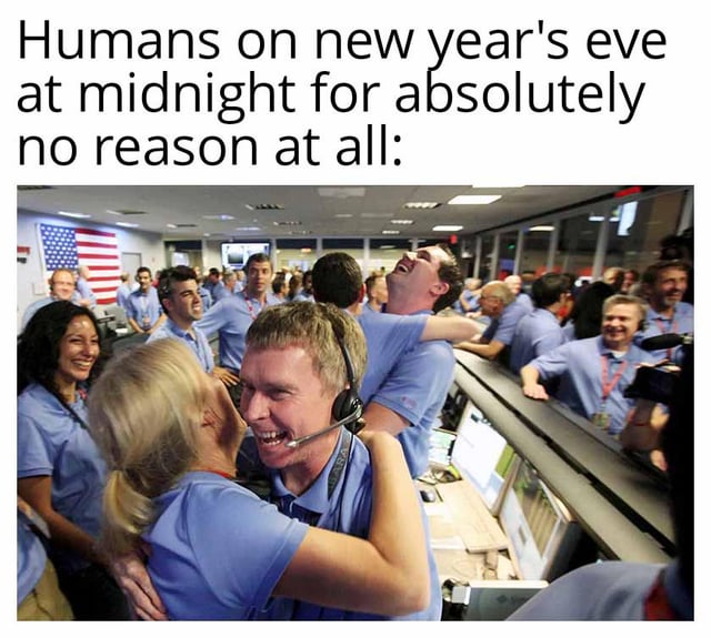 The meme consists of a top text caption stating 'Humans on new year's eve at midnight for absolutely no reason at all:' followed by a photograph of a group of people in blue uniforms celebrating joyfully in a professional control room. The scene includes individuals hugging, cheering, and smiling, with an American flag visible in the background, suggesting a mission control-like environment (possibly NASA). The humor arises from the ironic contrast between the text's claim of celebrating 'for absolutely no reason' and the context of the image, which appears to depict a significant achievement (e.g., a successful mission), implying humans intensely celebrate even trivial or 'unreasoned' moments like New Year's Eve.