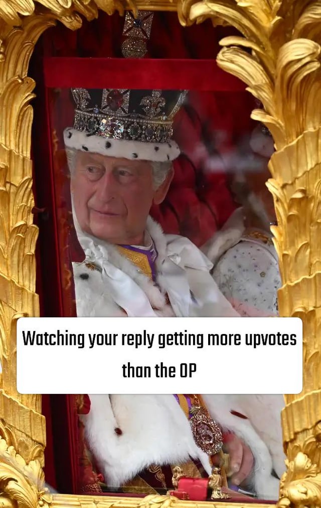 The meme features a photograph of King Charles III taken during his 2023 coronation, where he is seated in a lavishly decorated gilded royal carriage, wearing the official coronation crown and ceremonial white ermine robes with gold and purple regalia. He has a faint, smug, self-satisfied expression as he looks off to the side. A white text overlay is placed at the bottom of the image, reading 'Watching your reply getting more upvotes than the OP'. The joke draws a parallel between the elevated, triumphant feeling of being a newly crowned king and the relatable online experience of leaving a comment on a post that receives more likes/upvotes than the original post itself.
