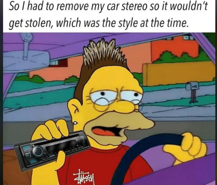 The image features an animated character from The Simpsons, identified as Comic Book Guy, sitting in a car. He is depicted driving with one hand on the steering wheel and the other holding a car stereo. The character has a yellow complexion, a distinctive hairstyle with spiked brown hair, and is wearing a red shirt with a white logo. The background shows a suburban street with houses, greenery, and a mailbox. At the top of the image, there is a text overlay that reads: 'So I had to remove my car stereo so it wouldn't get stolen, which was the style at the time.' The meme humorously references a past trend where people would remove car stereos to prevent theft, using the recognizable Simpsons character to add nostalgic and comedic appeal.