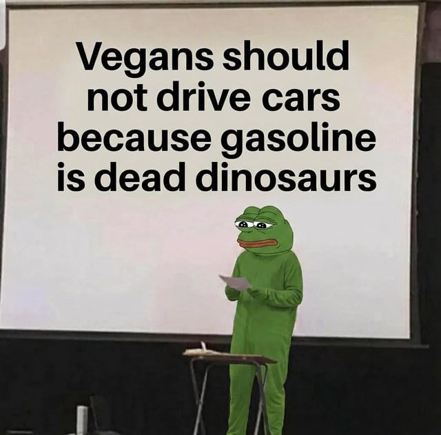 This is a lighthearted absurdist meme featuring a person wearing a Pepe the Frog mascot costume standing in front of a presentation projector screen. The text on the screen reads 'Vegans should not drive cars because gasoline is dead dinosaurs'. The joke plays on an oversimplified popular belief that fossil fuels are made from dead dinosaur remains, and absurdly extends vegan ethics of avoiding animal products to gasoline use, implying vegans should object to driving gasoline-powered cars. The deadpan smug expression of the Pepe character adds to the humorous delivery of the ridiculous argument.