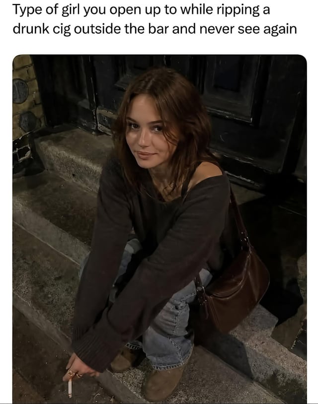 This is a single-panel relatable meme. The top of the meme features descriptive text, below which is a candid nighttime photo of a young woman with brown hair sitting on concrete steps outside a building. She is wearing an off-the-shoulder dark gray sweater, light wash jeans, and brown boots, carrying a brown leather shoulder bag, holding a lit cigarette in her hand, and looking at the camera with a soft, friendly small smile. The text at the top reads 'Type of girl you open up to while ripping a drunk cig outside the bar and never see again', referring to the common, relatable real-life experience of having a vulnerable, honest conversation with a kind stranger you meet briefly when stepping outside a bar to smoke while intoxicated, and never encountering that person again afterward.