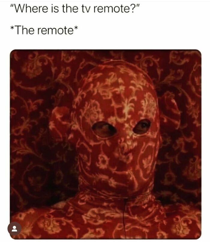 This meme jokes about the common frustrating experience of being unable to find a lost TV remote. The text at the top reads 'Where is the tv remote?' followed by '*The remote*' positioned above an image of a person wearing a full face and upper body covering with a red and gold ornate floral pattern that perfectly matches the patterned wallpaper behind them, making them almost completely blend into the background. The joke draws a comparison between the impossibly well-hidden remote and the perfectly camouflaged person in the image.