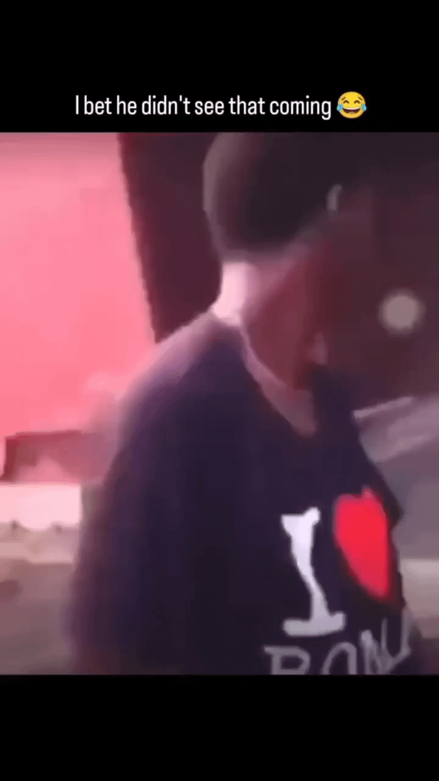 This is a low-quality optical illusion meme still frame showing a man standing partially turned away from the camera. Forced perspective and the image blur makes his head appear disconnected from his body, creating a shocking, unexpected visual gag that tricks viewers at first glance. The actual scene is just a trick of angle: the man's neck aligns with a gap or dark background behind him, creating the illusion of a separated head.