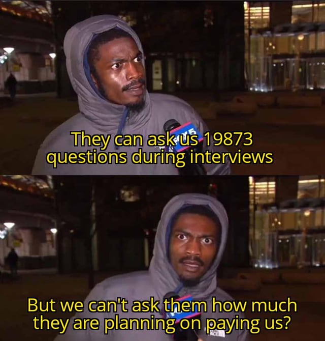 A two-panel meme featuring a man in a gray hoodie being interviewed on a city street at night. The top panel shows him with a confused/skeptical expression, with overlaid yellow text: 'They can ask us 19873 questions during interviews'. The bottom panel shows him with a shocked/frustrated expression, text: 'But we can't ask them how much they are planning on paying us?'. The meme critiques the double standard in job interviews where employers ask numerous questions but often avoid disclosing salary details.