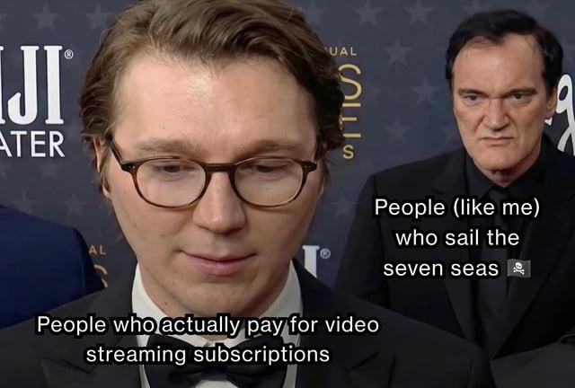 A comparison meme featuring two individuals at a formal event (likely a red carpet or awards ceremony). The foreground individual, wearing glasses and a suit, is labeled 'People who actually pay for video streaming subscriptions' with a neutral expression. The background individual, with a serious and intense demeanor (resembling Quentin Tarantino), is labeled 'People (like me) who sail the seven seas 🏴‍☠️'—a common internet euphemism for accessing pirated content. The contrast humorously juxtaposes legitimate streaming subscribers against those who use pirated media.