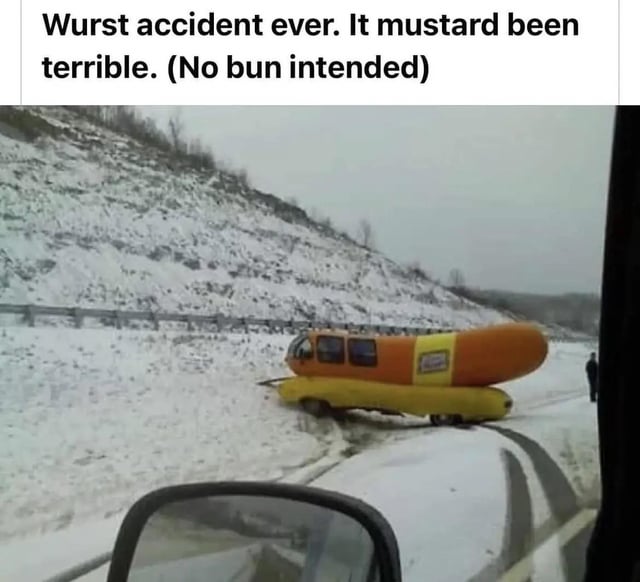 The image shows the Oscar Mayer Wienermobile, a hot dog-shaped vehicle, stuck or crashed in snow on a road. The photo appears to be taken from inside another vehicle, with a car's side mirror visible in the foreground. A person can be seen standing near the Wienermobile. Overlaid text at the top reads: 'Wurst accident ever. It mustard been terrible. (No bun intended)' which contains multiple food-related puns.