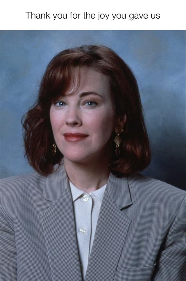 A meme featuring a portrait photograph of a person with shoulder-length brown hair, gold earrings, and wearing a gray blazer over a white collared shirt. The background is a soft blue gradient. At the top of the image, there is a white text overlay that reads 'Thank you for the joy you gave us', which conveys a sincere message of gratitude and appreciation towards the individual in the portrait.