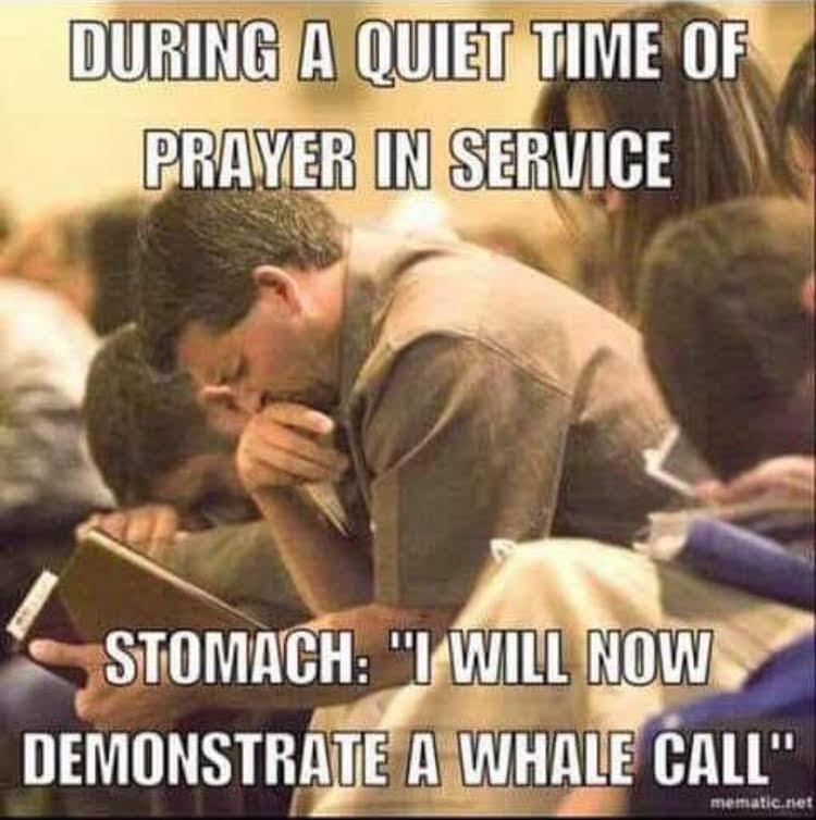 This humorous relatable meme shows a middle-aged man sitting in a crowded religious service, holding a notebook and pinching the bridge of his nose with a pained, embarrassed expression while other attendees bow their heads for silent prayer. The top overlay text establishes the solemn, quiet context: 'DURING A QUIET TIME OF PRAYER IN SERVICE'. The bottom text personifies the man's stomach speaking in the first person: 'I WILL NOW DEMONSTRATE A WHALE CALL'. The joke relies on the universal experience of awkward, loud involuntary bodily functions in quiet public settings, comparing the deep rumble of a stomach growl to a whale's vocalization, which would be highly embarrassing in the silent prayer context.