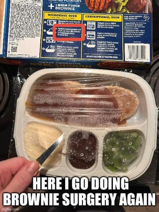 The meme has two main sections: the top shows the back of a frozen TV dinner package, with a circled cooking instruction step that requires cutting the plastic film covering the included brownie compartment before microwaving. The lower section shows a person's hand holding a small knife positioned to cut the plastic film over the brownie section of the still-frozen meal. The bottom overlaid text reads "HERE I GO DOING BROWNIE SURGERY AGAIN". The humor derives from exaggerating the trivial, mundane task of cutting the small piece of plastic as if it were a serious, formal surgical procedure, leaning into relatable, silly humor about following frozen dinner cooking instructions exactly.
