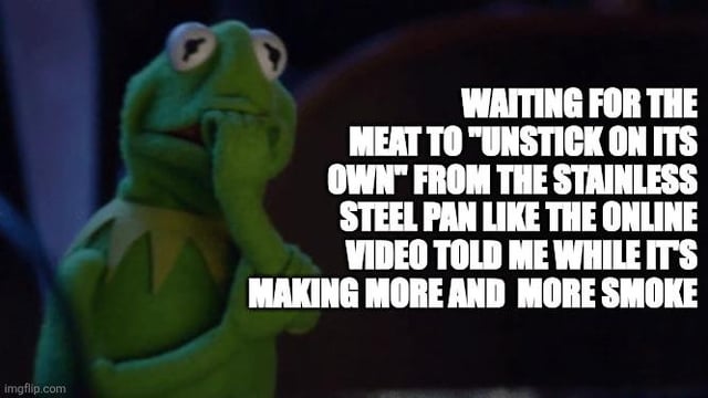 A meme featuring Kermit the Frog, a green Muppet character, displaying a concerned and thoughtful expression. He is shown holding his chin and looking off to the side, with overlaid text describing a relatable cooking mishap: waiting for meat to unstick from a pan as instructed by an online video, while smoke increasingly builds. The humor stems from the contrast between following tutorial advice and the chaotic reality of kitchen failures.