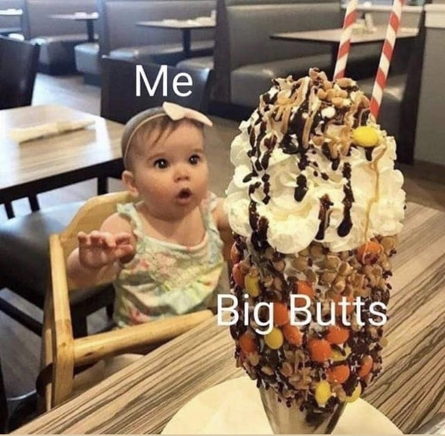 This is a single-panel reaction meme set in a casual restaurant. It features a young baby sitting in a wooden high chair with a shocked, excited expression (eyes wide, mouth open, one hand reaching forward) looking at an extremely large, over-the-top milkshake. The milkshake is heavily decorated with layers of whipped cream, chocolate syrup, chopped nuts, colorful candy pieces, and striped straws. Text labels are overlaid: the baby is marked 'Me' and the giant milkshake is marked 'Big Butts', creating a humorous comparison where the baby's awestruck, enthusiastic reaction to a very desirable, indulgent treat is used to represent the poster's excited, attracted reaction to seeing large buttocks.