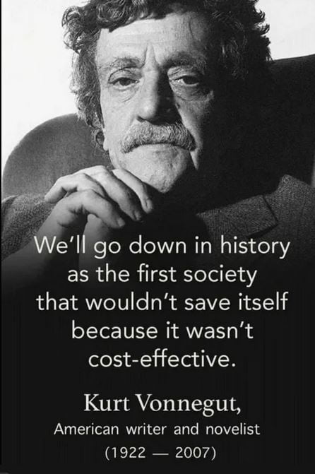 This is a black and white single image meme featuring a portrait of famous American novelist Kurt Vonnegut, who rests his clasped hands under his chin and looks at the viewer with a serious, contemplative expression. Overlaid on the lower portion of the image is a widely cited quote attributed to Vonnegut that critiques modern society's tendency to prioritize short-term cost-effectiveness over actions that would ensure long-term collective survival, followed by his name, professional title, and lifespan. The quote is frequently referenced in discussions of climate change inaction, systemic social neglect, and profit-first public policy.