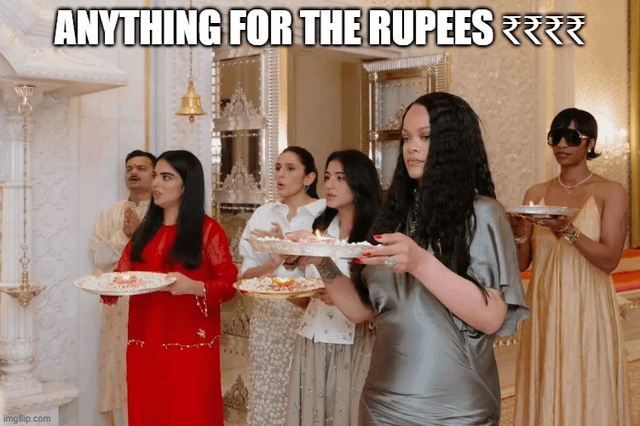 This meme features a real photograph of global pop star Rihanna standing in a line with other guests at the 2024 pre-wedding event of Anant Ambani, all holding plates with ceremonial offerings during a Hindu puja ritual held in an opulent, marble-decorated indoor venue. Bold white text is overlaid at the top of the image reading 'ANYTHING FOR THE RUPEES ₹₹₹₹₹', with the rupee (Indian currency) symbol repeated at the end. The sarcastic joke implies that Rihanna chose to participate in the unfamiliar cultural ritual and attend the event entirely because of the extremely large performance fee she was paid to appear at the high-profile billionaire family wedding.