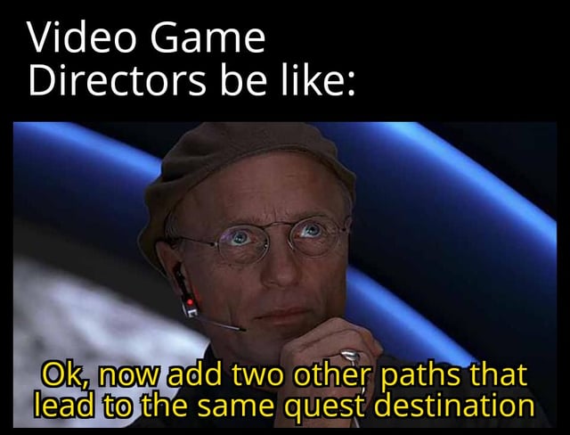A meme mocking the concept of 'player freedom' in video games, featuring a screenshot of a real man wearing glasses, a brown cap, and a headset with a microphone. The top text reads 'Video Game Directors be like:' in white, while the bottom text (attributed to the director) is in yellow: 'Ok, now add two other paths that lead to the same quest destination'. The humor lies in sarcastic commentary on how game developers often advertise multiple paths as 'player choice' when they ultimately result in the same outcome.