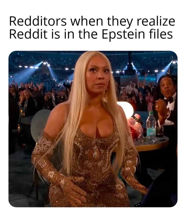 A meme consisting of a top text overlay and a screenshot of a real-life scene. The top text reads 'Redditors when they realize Reddit is in the Epstein files,' humorously depicting the hypothetical shocked reaction of Reddit users. The image shows a blonde woman with long hair wearing a gold dress, sitting in an audience (likely at an awards show or formal event), with a surprised expression and her hands slightly raised. A man in a tuxedo is visible in the background, clapping.