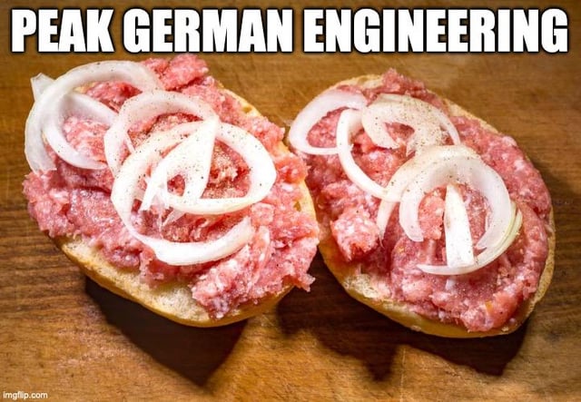 A meme featuring two open-faced sandwiches, likely Mettbrötchen (a traditional German dish consisting of ground pork spread on bread, topped with raw onion slices and seasoning), displayed on a wooden cutting board. The text 'PEAK GERMAN ENGINEERING' is prominently overlaid at the top in bold white capital letters. The humor stems from the satirical juxtaposition of the grandiose phrase 'peak German engineering'—typically associated with precision, advanced technology, or complex machinery—and the simple, rustic food item, playfully subverting the stereotype of German over-engineering by applying it to a humble, everyday sandwich.