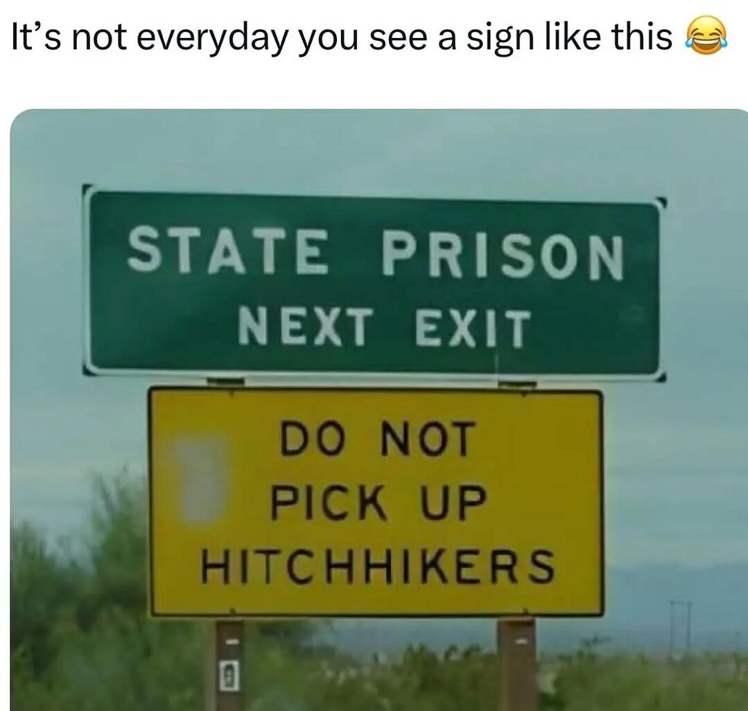 The image features two road signs mounted on poles against a sky background with some vegetation visible at the bottom. The top sign is a green highway sign with white text that reads 'STATE PRISON NEXT EXIT'. Directly below it is a yellow warning sign with black text stating 'DO NOT PICK UP HITCHHIKERS'. The humor comes from the implied connection between the two signs - suggesting that hitchhikers near a prison exit might be escaped inmates, making the warning sign particularly relevant and creating a funny juxtaposition. At the top of the image, there's a caption that reads 'It's not everyday you see a sign like this 😂' which emphasizes the unusual and humorous nature of the sign combination.