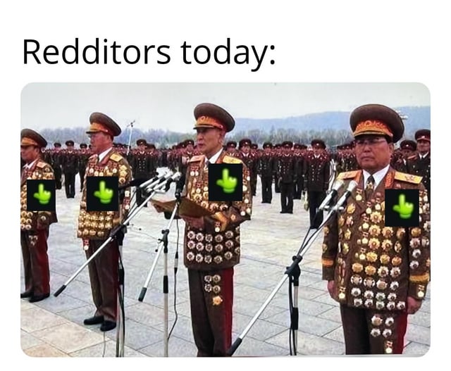 The image features a satirical meme with the top text 'Redditors today:'. Below the text is a photograph of military personnel in ornate, medal-covered uniforms standing in formation at a parade, with multiple microphones positioned in front of them. The faces of the central figures are obscured by green middle finger emojis, creating a contrast between the严肃 military setting and the rude gesture, likely mocking or commenting on the behavior of Redditors.
