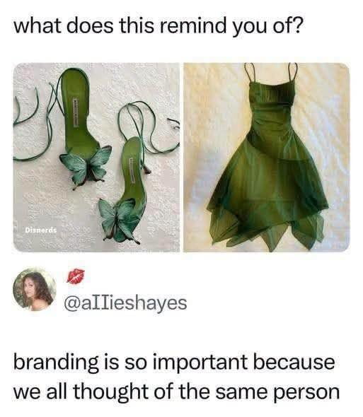 This meme opens with the question 'what does this remind you of?' placed above two side-by-side fashion images: the left shows a pair of dark green satin lace-up high heels decorated with large teal butterfly accents on the toes, and the right shows a matching forest green spaghetti strap short dress with a flowy, asymmetric tulle hem that evokes a fairy aesthetic. Below the fashion images is a comment from user @aIIieshayes that reads 'branding is so important because we all thought of the same person'. The unspoken shared reference most viewers make is to Tinker Bell, the iconic green fairy character from Disney's Peter Pan franchise, as the outfit perfectly matches her signature color and fairy style.