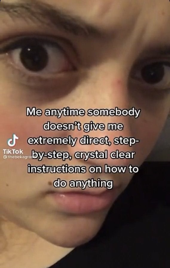 The meme is a close-up selfie of a young person with wide, alarmed eyes and a confused, slightly frustrated expression. Overlaid on the center of the image is white text with a black outline that reads: 'Me anytime somebody doesn't give me extremely direct, step-by-step, crystal clear instructions on how to do anything'. The meme humorously captures the very relatable experience of feeling lost or overwhelmed when given vague, unclear directions for any task, whether personal, work-related, or academic.