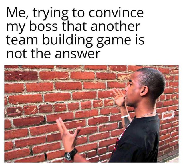 The meme consists of two main parts: a top text overlay and a photograph below. The text reads, 'Me, trying to convince my boss that another team building game is not the answer.' Below the text is an image of a person standing sideways, facing a red brick wall, with their hands raised and gesturing as if speaking to the wall. The humor stems from the metaphor of 'talking to a brick wall,' implying the boss is unresponsive or unwilling to listen to the argument against more team building games.