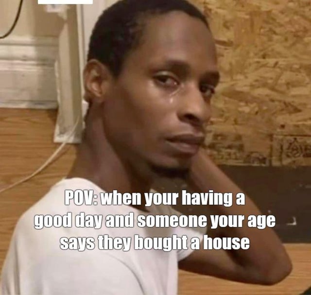 This is a static single-image reaction meme. The main subject is a Black man wearing a plain white T-shirt, with visible tears on his face, showing a suppressed, disappointed and sad expression as he turns his head to look toward the camera. The overlaid white text on the image reads "POV: when your having a good day and someone your age says they bought a house". The meme humorously expresses the common relatable feeling of frustration, anxiety and deflation that young adults experience when they learn that a peer of the same age has achieved the major financial milestone of buying a house that they have not yet reached, instantly ruining their previously good mood.