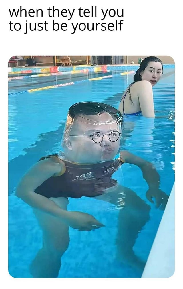This is a humorous edited meme set in an indoor public swimming pool. In the foreground, a man wearing round glasses and a dark flotation vest stands partially submerged in shallow pool water. A transparent cylindrical glass filled with water is photoshopped over his head, creating the absurd visual that his head is encased in a water-filled glass, with a blank, awkward expression on his face. In the background, a woman in a blue swimsuit turns to look at the man with a visibly confused, judgmental expression. The text at the top of the meme reads 'when they tell you to just be yourself', playing on the relatable joke that following common advice to be your authentic self often leads to awkward, bizarre situations where other people judge you negatively.