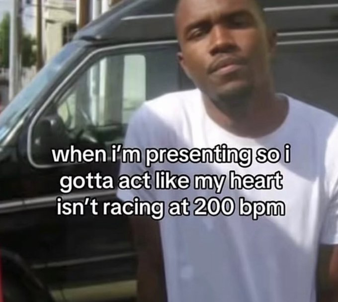 This relatable reaction meme features a photograph of rapper Kanye West standing outside next to a dark-colored SUV, with a completely neutral, outwardly calm facial expression. White text with a black outline is overlaid on the lower half of the image, reading 'when i'm presenting so i gotta act like my heart isn't racing at 200 bpm'. The meme jokes about the universal experience of public speaking anxiety, where people force a calm, collected appearance when giving presentations, despite feeling extremely nervous and having a rapidly beating heart internally.