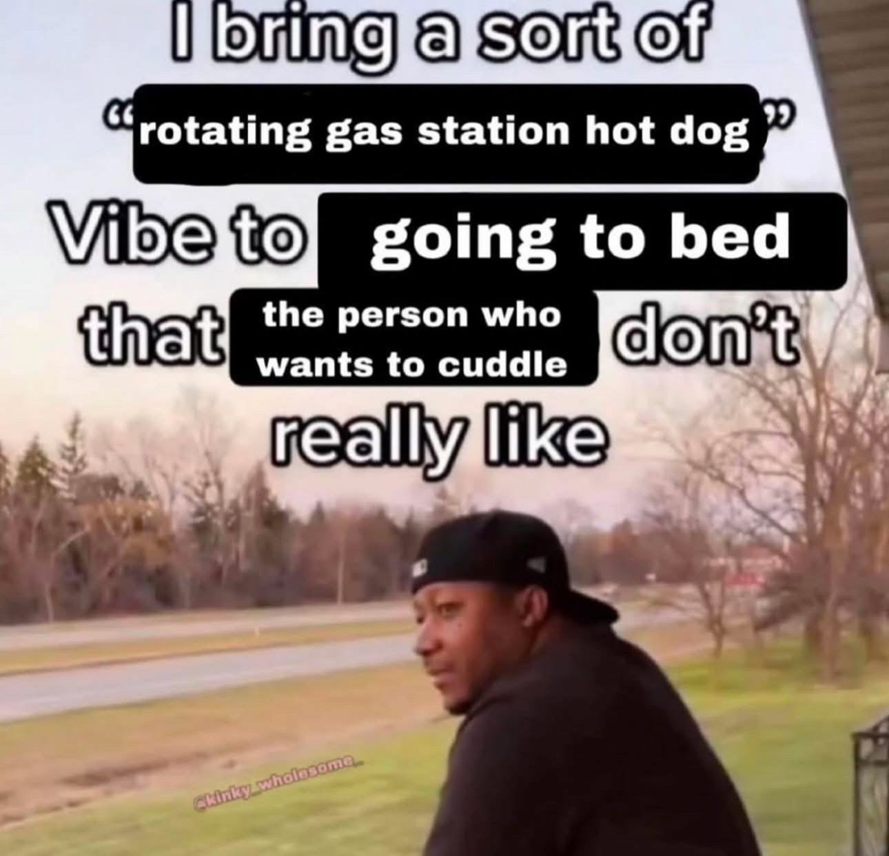 This meme uses the popular 'I bring a sort of X vibe that Y don't really like' reaction format. It features a Black man in a backwards black cap looking over his shoulder skeptically, set against a rural roadside background with bare trees and a road. The overlaid text reads: 'I bring a sort of "rotating gas station hot dog" Vibe to going to bed that the person who wants to cuddle don't really like'. The joke relies on the widely understood cultural reference of gas station rotating hot dogs being unappealing, low-quality, and undesirable, comparing that reputation to the creator's uninviting, un-cuddly demeanor when they are preparing to sleep, humorously admitting they are not a good cuddle partner at bedtime.