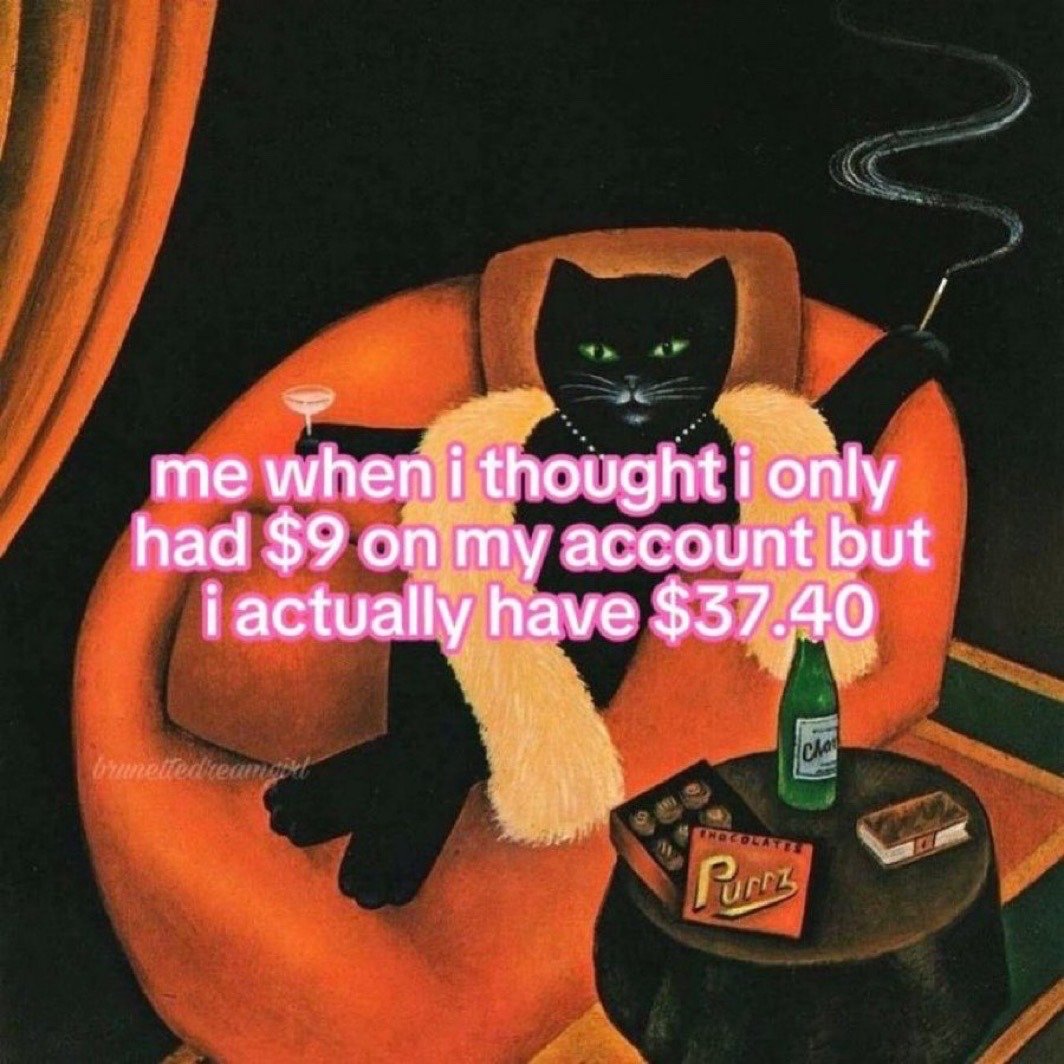 The meme displays a stylized illustration of a sophisticated anthropomorphic black cat wearing a fur stole and pearl necklace, lounging luxuriously in a plush orange armchair. The cat holds a cocktail in one paw and a cigarette holder in the other, with a side table next to it holding a bottle of champagne, a box of "Purrz" branded chocolates, and a pack of cigarettes. Pink overlaid text on the image reads "me when i thought i only had $9 on my account but i actually have $37.40", humorously depicting the relatable feeling of pleasant surprise when you discover you have more disposable money than you expected, framing the relatively small extra sum as a major luxury win.