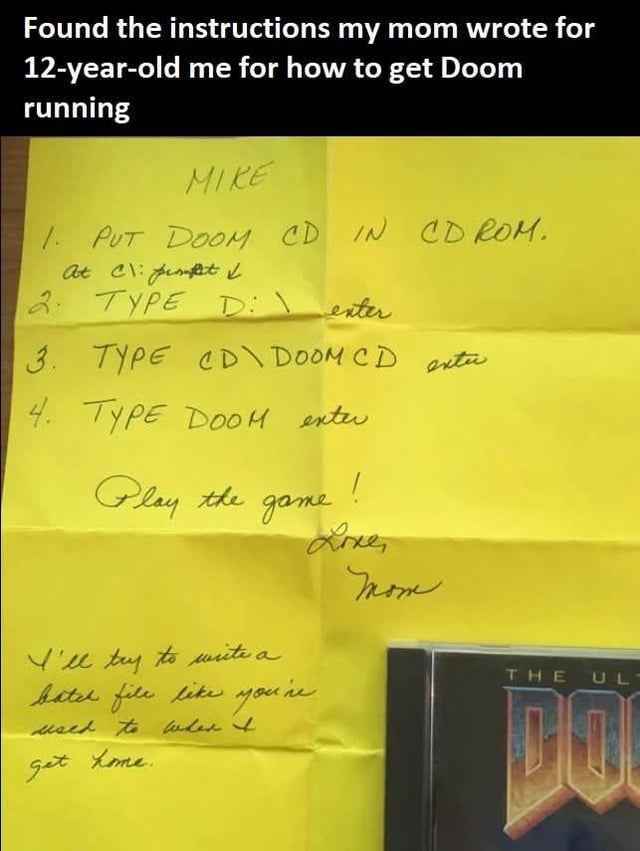 The image shows a Reddit post featuring a photo of a crumpled yellow handwritten note next to a partial view of an original Ultimate Doom game CD case. The post overlay text at the top states the poster found old instructions their mom wrote for 12-year-old them to run the classic game Doom. The handwritten note is addressed to Mike, listing four simple DOS commands to launch Doom from its CD, followed by a warm sign-off from his mom encouraging him to play, plus an extra note that she will write a more convenient batch file for the game when she returns home. The post is a nostalgic, feel-good nod to 1990s/early 2000s PC gaming and supportive parenting.