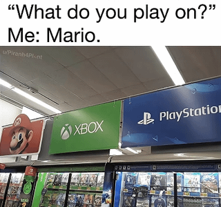 This is a humorous gaming pun meme. The top text has a question: "What do you play on?", followed by the poster's answer: "Me: Mario.". The image below is a photo taken inside a video game retail store, showing separate branded sections for consoles: Mario gets his own dedicated signage section alongside major console brands Xbox (green) and PlayStation (blue). The joke relies on wordplay: the question asks what gaming console/platform the person plays games on, but instead of answering Nintendo, they answer Mario, which is literally treated as its own platform/section just like Xbox and PlayStation in the store, leaning into the common association that Nintendo consoles are primarily known for Mario games.