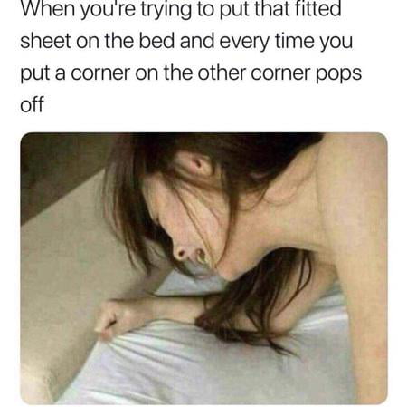 The meme features a top text overlay and a photograph below. The text reads: 'When you're trying to put that fitted sheet on the bed and every time you put a corner on the other corner pops off,' describing the common household struggle of fitting a fitted sheet. Below the text is a photograph of a real woman with long dark hair, her face pressed down onto a bed mattress, appearing visibly frustrated or exhausted, visually representing the struggle mentioned. The image captures the relatable frustration of this everyday chore through the combination of descriptive text and expressive imagery.