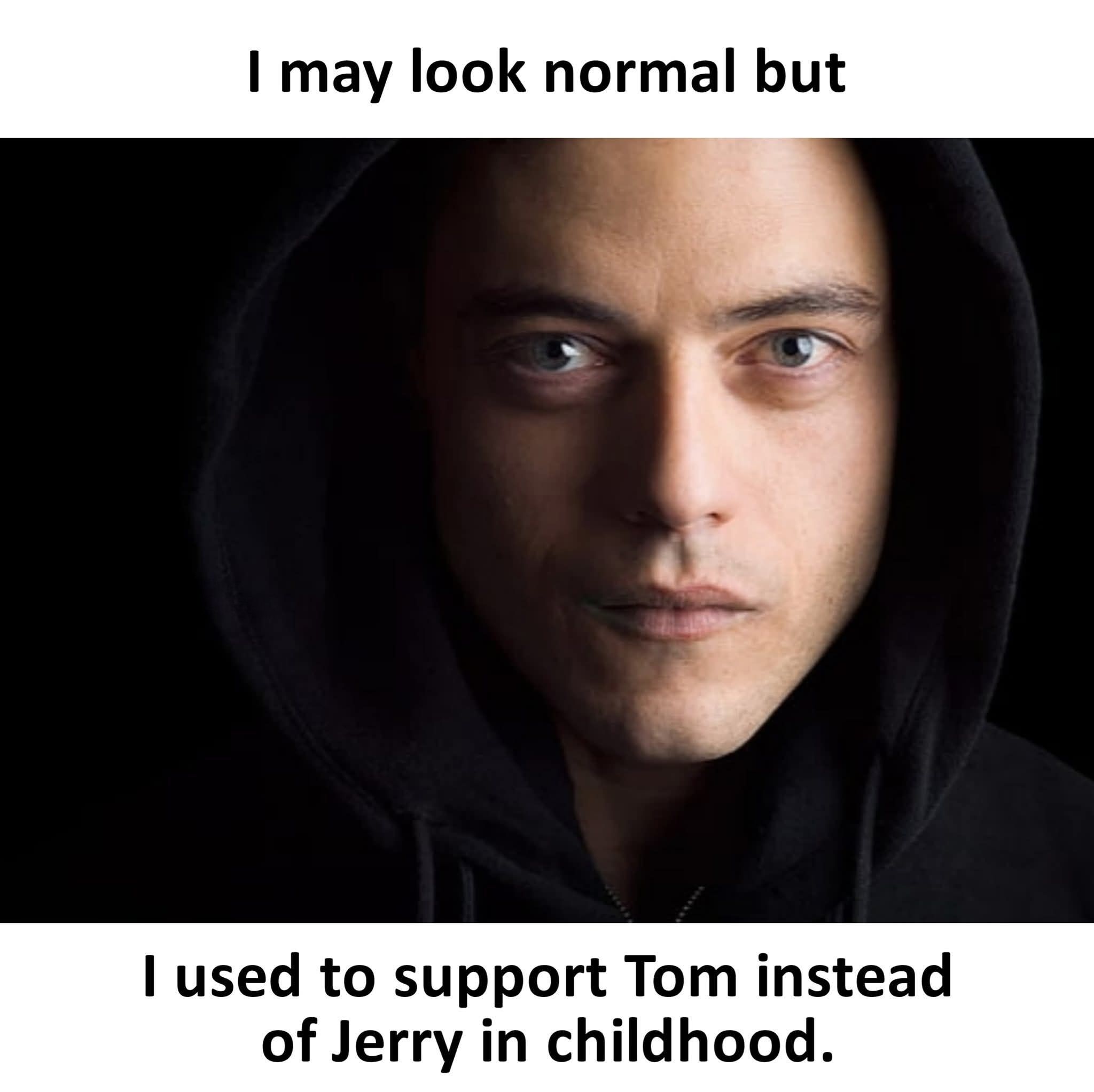 This is a single image meme featuring a promotional still of Rami Malek as his character Elliot Alderson from the TV show Mr. Robot, wearing a black hoodie and staring intently at the viewer with a serious, brooding expression. The top overlaid text reads 'I may look normal but', and the bottom text delivers the punchline: 'I used to support Tom instead of Jerry in childhood.' The joke plays on the common cultural consensus that Jerry the mouse is the sympathetic protagonist of the *Tom and Jerry* cartoons, so supporting the cat Tom is framed as an unexpected, almost 'edgy' secret that contrasts with a person's normal outward appearance, leaning into the secretive, anti-establishment vibe of the Mr. Robot character.