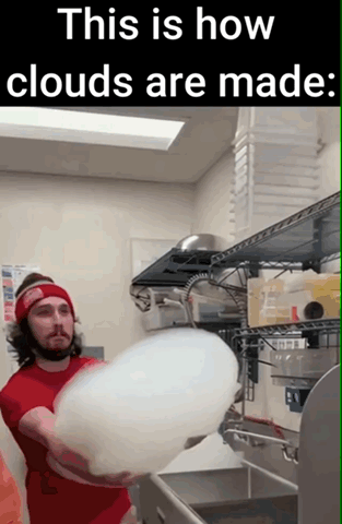 The meme features text at the top reading 'This is how clouds are made:' above a photograph of a bearded man wearing a red headband and red t-shirt, standing in a commercial kitchen or candy production space. The man is holding an extremely large, fluffy, perfectly white ball of cotton candy that looks nearly identical to a cumulus cloud. The humor comes from the absurd, deadpan false explanation of natural cloud formation, playing directly on the visual similarity between the oversized cotton candy and real clouds.