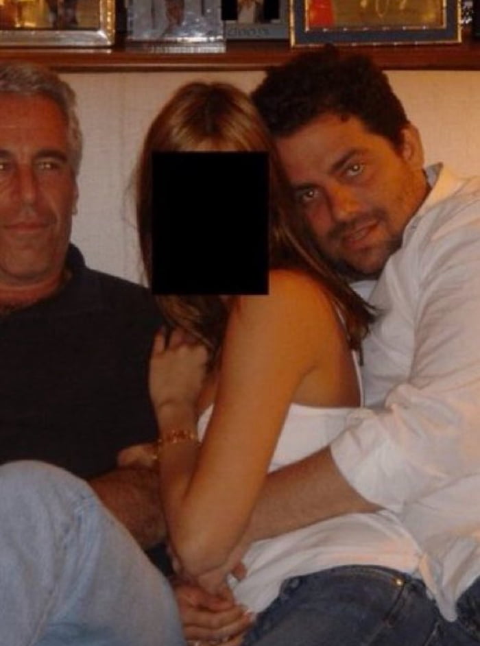 A photograph showing three people sitting closely together on a couch. An older man with gray hair is on the left, a younger man with dark hair is on the right, and a woman with long blonde hair is in the middle with her face obscured by a black rectangle. The image is presented with the context of a meme about 'the director of the recently released Melania movie.'