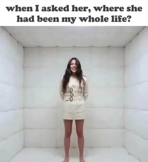 The meme has bold black text at the top that reads 'when I asked her, where she had been my whole life?', a widely used cheesy romantic pickup line meant to convey that the speaker feels they have found their ideal partner. Below the text is a photo of a barefoot woman with long dark hair, wearing a beige straitjacket, laughing wildly while standing alone in an all-white padded psychiatric holding room. The humor comes from the subversion of expected romantic reactions to the pickup line: the line is implied to be so absurd, cringey, or delusional that the woman has been involuntarily committed to a mental institution, or alternatively that the unwell speaker is hitting on a patient who already resides in the psych ward.