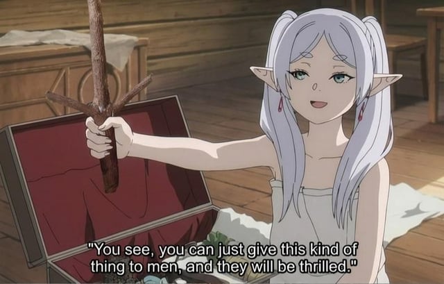 An animated meme image featuring a white-haired elf-like girl with pointed ears, wearing a white dress, sitting on a wooden floor next to an open red-lined chest. She holds a simple wooden stick in her right hand and smiles amusedly. The image includes overlaid text: "You see, you can just give this kind of thing to men, and they will be thrilled." The scene humorously stereotypes men as being easily pleased by simple, seemingly unremarkable objects like sticks.