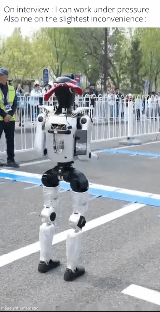 The meme presents a relatable expectation vs reality joke about job interview claims. The top text first states 'On interview : I can work under pressure', followed by 'Also me on the slightest inconvenience :'. Below the text is a photograph of a bipedal humanoid robot at an outdoor public event, seemingly hunched over and malfunctioning mid-activity on a marked race track, with event staff and onlookers behind white barricades in the background. The joke draws a humorous parallel between the exaggerated capability people claim during interviews to handle high pressure, and how quickly they become overwhelmed by even minor inconveniences in real life.
