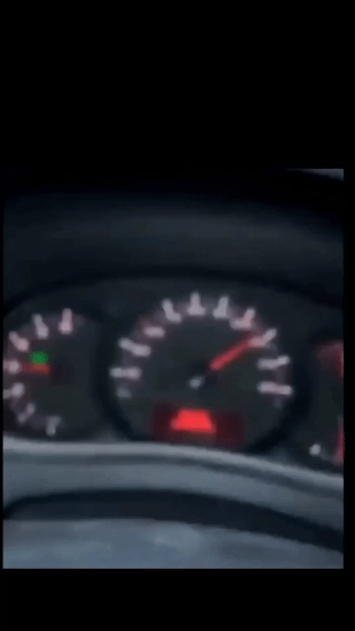 This is a blurry photograph taken from inside a car, showing the vehicle's dashboard tachometer (engine revolution counter). The tachometer needle is positioned deep in the high-RPM red zone, meaning the engine is being revved far beyond its safe operating limit. The meme's title jokes that this extreme over-revving will destroy the engine's pistons, implying the engine is about to fail.