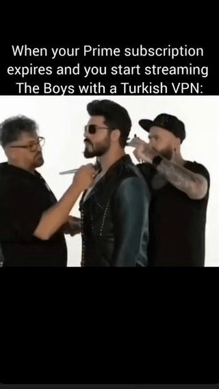 The meme has a black top bar with white text that reads 'When your Prime subscription expires and you start streaming The Boys with a Turkish VPN:' above a photograph. The photo features a man with dark hair, a beard, and sunglasses that looks nearly identical to a low-quality, bootleg version of Billy Butcher, a lead character from Amazon Prime's series The Boys, standing passively while two crew members apply makeup and style his hair. The joke aligns with the original post title naming the character 'Billie Butcher from Temu', referencing Temu's reputation for selling cheap, low-quality knockoff versions of popular products, and the common internet practice of using Turkish VPNs to access lower-priced streaming subscriptions, implying this low-effort bootleg character is what users get when they use this method to stream the show.