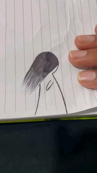 The image displays a simple hand-drawn pen doodle on a sheet of lined notebook paper, held at the right edge by a person's visible fingers. The doodle is a clever visual double entendre: it can be interpreted as a slouched, exhausted stick figure with long dark hair covering their face, and simultaneously as three limp, hanging lowercase 'c' shapes that represent the eponymous three remaining brain cells. The visual joke illustrates the feeling of being completely mentally drained and barely functional while sitting for an exam, a common relatable experience for students.