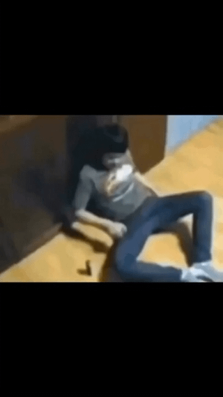 This absurdist meme features a low-resolution still of a young man who appears dazed and injured, slumped against an interior wall while seated on a wooden floor. The comedic effect comes from the pairing of this violent-looking visual with the mundane, trivial title about choosing between boiled and fried egg, creating an anti-joke where an extremely negative consequence is implied for an insignificant everyday food choice with no additional context provided.