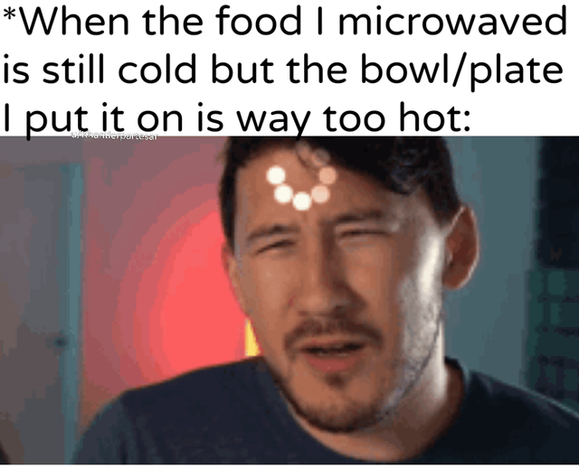 A meme featuring a screenshot of a man with a frustrated expression, squinting his eyes. The top text reads: 'When the food I microwaved is still cold but the bowl/plate I put it on is way too hot:'. The background has a red hue, and there's a watermark 'u/MonsterMunchLeg' in the top left corner. The meme humorously depicts the relatable everyday frustration of microwaving food where the container gets excessively hot while the food remains cold.