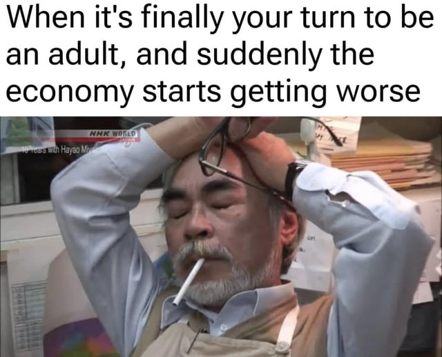 A meme composed of a top text caption and a photograph. The text reads: 'When it's finally your turn to be an adult, and suddenly the economy starts getting worse'. Below the text is an image of an older man with gray hair, a mustache, and beard, appearing visibly stressed. He is holding his head with both hands, has a cigarette in his mouth, and is dressed in a light blue dress shirt under a beige apron. The background features a cluttered workspace with papers and a window. A watermark 'NHK WORLD' is visible in the top left corner of the image, indicating the source of the original photograph.